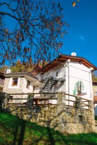 a house behind a stone wall with a fence at Casa del Castagno in Pulfero