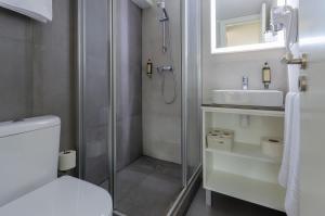a bathroom with a shower and a toilet and a sink at Ver Belém Suites in Lisbon