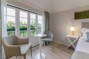 a bedroom with a bed and a table and chairs at Ver Belém Suites in Lisbon
