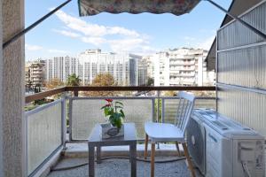 balkon ze stołem i telewizorem na balkonie w obiekcie Athens Heartbeat w Atenach