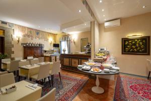 a dining room with a table and chairs and a kitchen at Hotel Davanzati in Florence