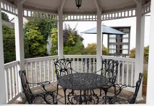 a table and chairs on a porch with an umbrella at The Angus Hotel & Spa in Blairgowrie