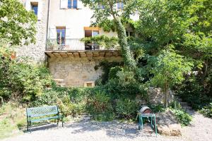 un banco verde frente a un edificio en The Balcony Gîte - Riverside Lagrasse, en Lagrasse