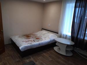 Lys'vaにあるApartment on Smishlyaeva 28の小さなベッドルーム(ベッド1台、テーブル付)