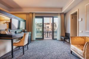 a hotel room with a desk and a balcony at Eurostars Danube Budapest in Budapest