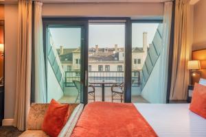 a bedroom with a bed and a large window at Eurostars Danube Budapest in Budapest