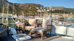 a deck of a boat with chairs and a marina at Your own private yacht (17m) on the beach in Barcelona