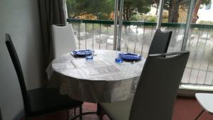 ラ・グランド・モットにあるstudio proche de la merの白いテーブルクロスと青い皿が置かれたテーブル