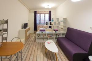 a living room with a purple couch and a table at Garsoniere Central in Satu Mare