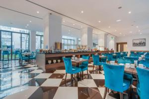 a restaurant with blue chairs and a bar at Eurostars Danube Budapest in Budapest