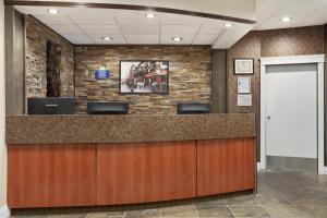 a lobby with a reception desk with a brick wall at Days Inn by Wyndham Sylvan Lake in Sylvan Lake