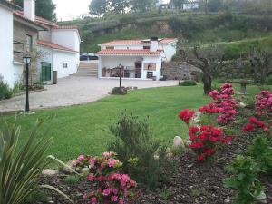a house with pink flowers in a yard at Quinta Vale do Nox in Serrazes
