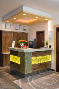 a lobby with a reception counter with yellow lights at Waldhotel Sindelfingen am Eichholz in Sindelfingen