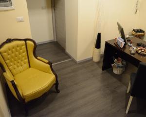 a living room with a yellow chair and a desk at B&B Massimo Centro in Catania