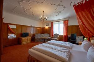 a bedroom with a bed and a chair and a chandelier at Haus Daheim in Oberstaufen