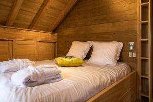 a bed in a log cabin with towels on it at La Datcha de Liza in Metzeral