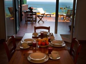 a table with plates and bowls of fruit on a balcony at Residenza Turistico Alberghiera Le Poste del Pianone in Santa Liberata