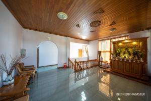 a living room with a wooden ceiling and a hallway at Gypsy Inn in Nyaungshwe Township