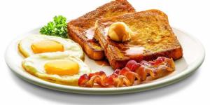 a white plate with eggs and toast and bacon at Bay Gardens Marina Haven in Gros Islet