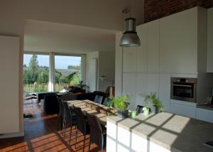 博爾赫隆的住宿－De Waterkriek，厨房以及带桌椅的起居室。