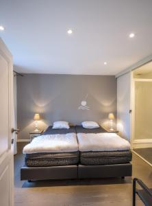 1 dormitorio con 1 cama con 2 almohadas en De Waterkriek, en Borgloon