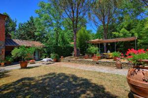 a yard with a patio and a pavilion with flowers at Villa Elisa by PosarelliVillas in Cortona