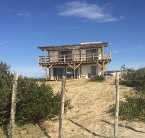 una casa en la playa con una valla delante en Las Dunas, en La Pedrera