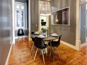 une salle à manger avec une table et des chaises noires dans l'établissement Lisbon Canaan Boutique Apartments Fanqueiros 114 by Get Your Stay, à Lisbonne