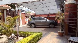 une voiture garée dans un parking à côté d'un bâtiment dans l'établissement Apartamento Golden Junior, à Cochabamba