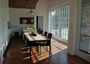 a dining room with a table and black chairs at De Waterkriek in Borgloon