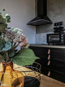 a vase with flowers on a table in a kitchen at Stylový apartmán přímo u lanovky, vlastní garážové stání in Janske Lazne