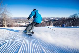 una persona sta sciando su una pista innevata di Mont Blanc Hôtel & Condos a Saint-Faustin