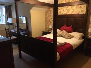 a bedroom with a four poster bed and a desk at True Lovers Knot in Blandford Forum