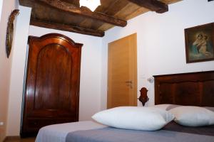 a bedroom with a bed with a wooden headboard at Casa del Castagno in Pulfero