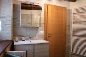 a bathroom with a sink and a wooden door at Casa del Castagno in Pulfero +31 photos