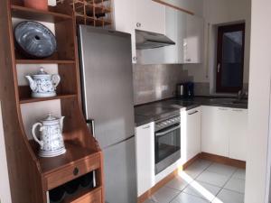 a kitchen with white cabinets and a stainless steel refrigerator at Ferienwohnung am Weinberg - Altenahr / Ahrtal in Altenahr