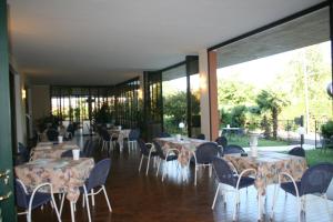 a restaurant with tables and chairs and large windows at Residence Miralago Rooms & Apartments in Manerba del Garda