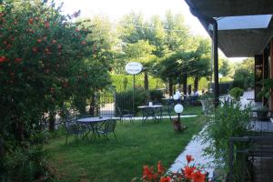 un patio con mesas y sillas y un cartel en el césped en Residence Miralago Rooms & Apartments, en Manerba del Garda