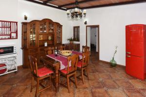 een eetkamer met een tafel en een rode koelkast bij Casa Acosta in Tazacorte
