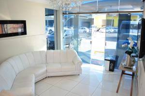 a white couch sitting in a room with a window at Hotel Novo Sol in Petrolina