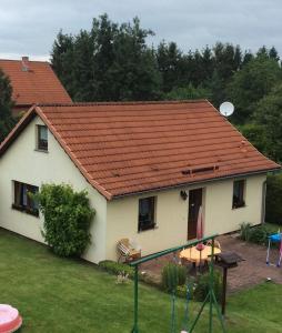 une maison blanche avec un toit orange et une cour dans l'établissement Ferienhaus Greiling, à Quedlinbourg