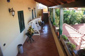 einen Balkon eines Hauses mit einer Bank und Blumen in der Unterkunft Hotel Grillo Verde in Torre Annunziata