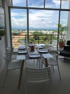 a dining room table with chairs and a large window at Girardot Deluxe in Girardot