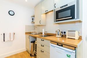 a kitchen with a sink and a microwave at Snug at Combe Hay in Bath