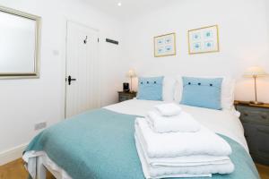 バースにあるSnug at Combe Hayのベッドルーム1室(青と白のベッド、タオル付)