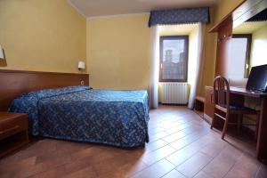 una camera da letto con un letto, una scrivania e un computer di Albergo Dei Leoni a Monterotondo
