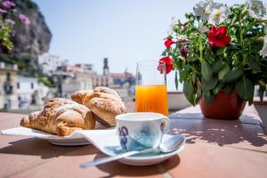 a table with a plate of bread and a glass of orange juice at Casa Ester in Atrani