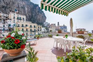 a balcony with a table and chairs and a view of the city at Casa Ester in Atrani