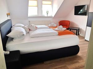 um quarto com 2 camas e uma cadeira vermelha em Ferienwohnung "Alte Fleischerei" Freiberg Sachsen em Freiberg