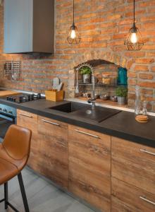 a kitchen with a sink and a brick wall at St. Mark's Boutique Apartment Zagreb in Zagreb
